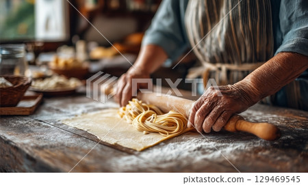 Hands create fresh pasta in a cozy kitchen during a sunny afternoon 129469545