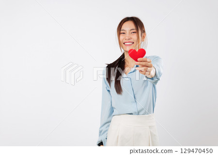 An attractive Asian woman holds a red heart, love day emotion valentine concept, a cheerful way to share the valentine day feeling for romance, headshot isolated studio white background An attractive Asian woman holds a red heart, love day emotion valentine concept, a cheerful way to share the valentine day feeling for romance, headshot isolated studio white background 129470450