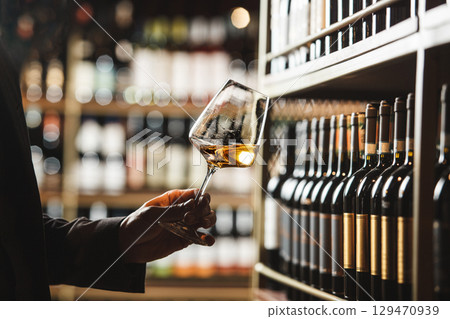 Wine Expert Evaluating Color of White Wine in Cellar Wine Expert Evaluating Color of White Wine in Cellar 129470939