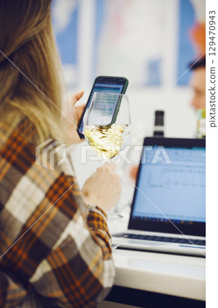 Sommelier Assessing White Wine and Taking Notes Sommelier Assessing White Wine and Taking Notes 129470943
