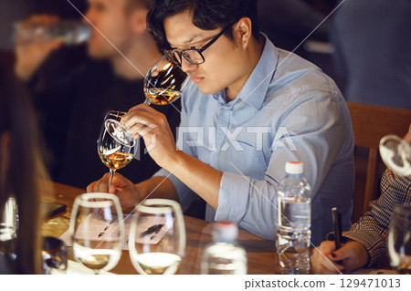 Man Sitting at Table With Glass of Wine Man Sitting at Table With Glass of Wine 129471013