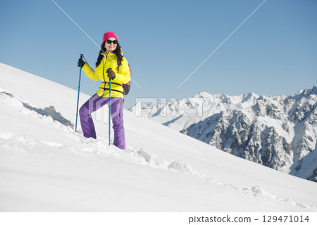 Joyful Woman Celebrates the Ascent of Snow-Capped Mountain Peak Joyful Woman Celebrates the Ascent of Snow-Capped Mountain Peak 129471014