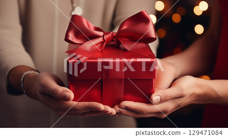 Giving gifts during the celebrating happy birthday. Woman hands holding a gift box. 129471084