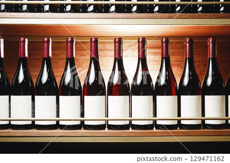 Row of Red Wine Bottles With Blank Labels on Wooden Shelf in Cellar Row of Red Wine Bottles With Blank Labels on Wooden Shelf in Cellar 129471162