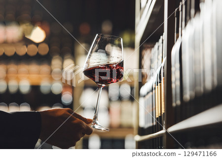 Wine Expert Expertly Swirling Glass of Red Wine in Cellar Environment Wine Expert Expertly Swirling Glass of Red Wine in Cellar Environment 129471166