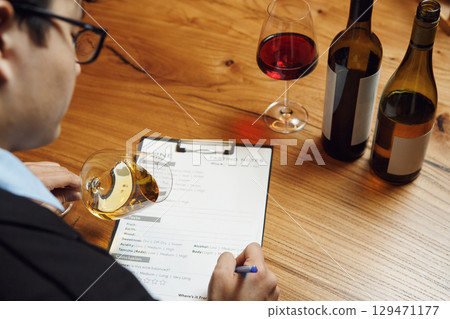 Sommelier Holding Clipboard and Glass of Wine Sommelier Holding Clipboard and Glass of Wine 129471177