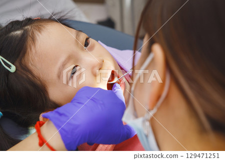 Little Girl Getting Her Teeth Checked by Dentist 129471251