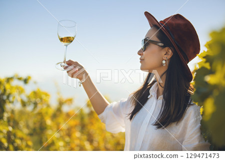 Woman Tasting White Wine in Glass on Plantation of Vineyard Woman Tasting White Wine in Glass on Plantation of Vineyard 129471473