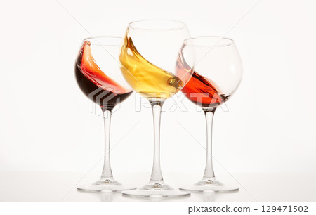 Rose, white, red wines splashes in stemware. 129471502