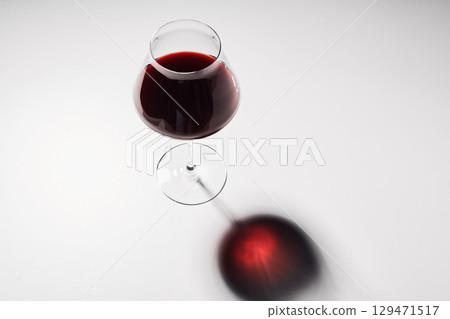 Red wine is in wineglass isolated on white background. 129471517