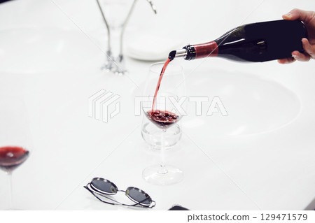 Close-up of sommelier pouring red wine into wine glass. Training and wine tasting. Close-up of sommelier pouring red wine into wine glass. Training and wine tasting. 129471579