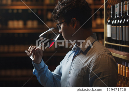 Man Tasting Wine in Wine Cellar 129471726