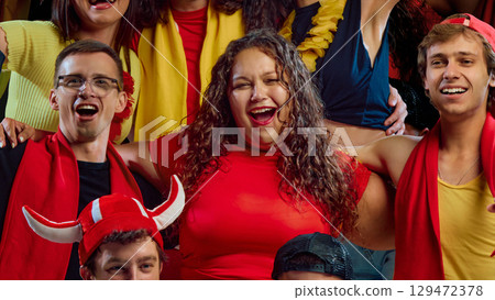 Smiling football fans embracing at game Smiling football fans embracing at game 129472378