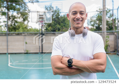 Confident Latin man on outdoor basketball court, sports fitness and athletic lifestyle portrait Confident Latin man on outdoor basketball court, sports fitness and athletic lifestyle portrait 129473524