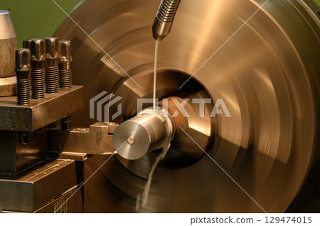 The lathe machine finish cut metal shaft parts with liquid coolant method. 129474015