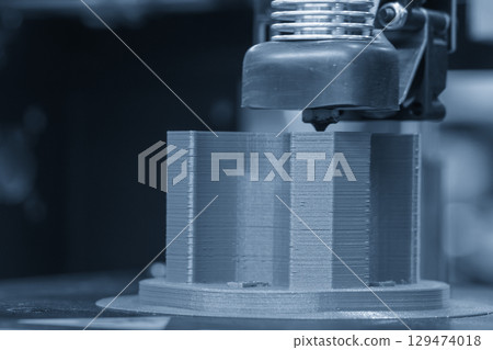 Close up scene the 3D model operation by additive manufacturing by 3D printer machine in the blue tone. Close up scene the 3D model operation by additive manufacturing by 3D printer machine in the blue tone. 129474018
