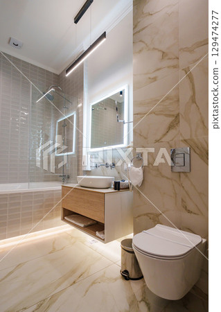 The interior of a modern bathroom is in beige tones.  129474277