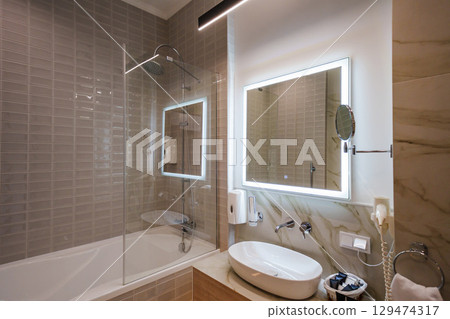 The interior of a modern bathroom is in beige tones.  129474317