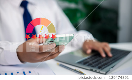 Customer satisfaction and business quality review.Businessman giving five-star rating and positive feedback on smartphone, laptop and performance gauge in background. 129474891