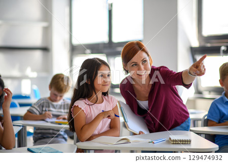 Teacher talking with children in primary class. 129474932