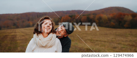 Senior couple embracing in autumn sunset light. Senior couple embracing in autumn sunset light. 129474966