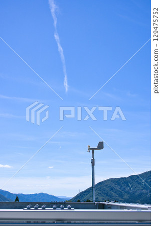 Blue sky and wind vane measuring wind speed and velocity Blue sky and wind vane measuring wind speed and velocity 129475752