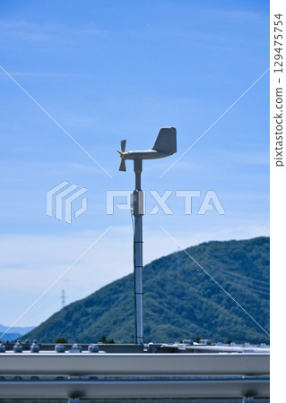 Blue sky and wind vane measuring wind speed and velocity Blue sky and wind vane measuring wind speed and velocity 129475754