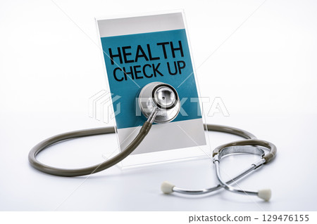 Stethoscope rests against sign that reads Health Check Up, symbolizing medical examination and healthcare. image conveys sense of professionalism and care Stethoscope rests against sign that reads Health Check Up, symbolizing medical examination and healthcare. image conveys sense of professionalism and care 129476155