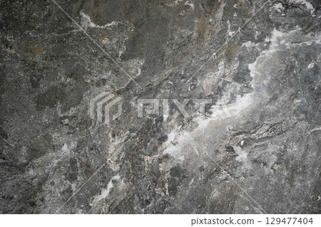 a textured dark gray stone surface with natural white and light gray streaks and patterns a textured dark gray stone surface with natural white and light gray streaks and patterns 129477404