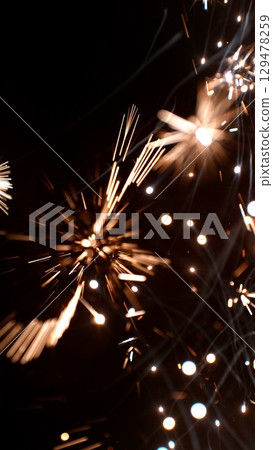 new year sparkler, fireworks. burning sparkler firework. Happy new year and Merry christmas concept. Happy holidays. Abstract blurred of Sparklers for celebration. Magic light. Winter Xmas decoration. new year sparkler, fireworks. burning sparkler firework. Happy new year and Merry christmas concept. Happy holidays. Abstract blurred of Sparklers for celebration. Magic light. Winter Xmas decoration. 129478259
