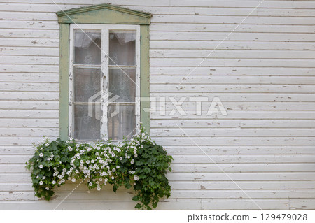 Vintage wooden window with flower box on white weathered house wall 129479028