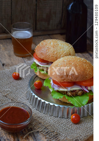 veggie burgers with a chop of eggplant, lettuce, pickled onions, tomato on a brown wooden background. veggie burgers with a chop of eggplant, lettuce, pickled onions, tomato on a brown wooden background. 129480109