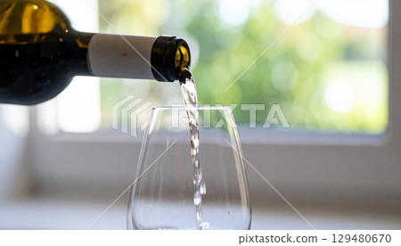 在柔和的自然光下，葡萄酒被倒入醒酒器的特寫鏡頭 129480670