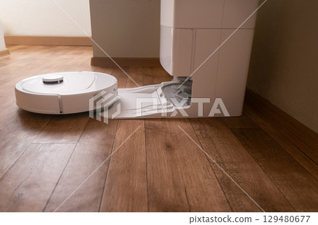 After completing its cleaning cycle the robot vacuum autonomously navigates back to the charging station for recharge and maintenance. 129480677