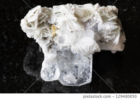 Goshenite with mica and feldspar mineral on black 129480850