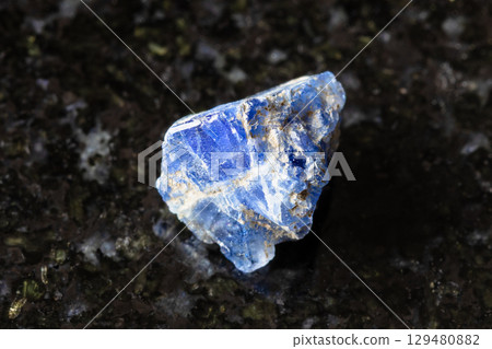 sample of raw benitoite mineral on black granite 129480882