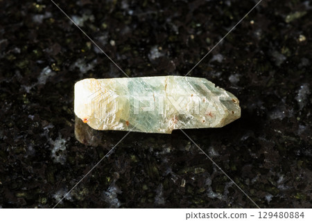raw green sapphire corundum crystal on black 129480884