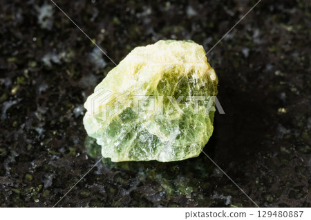 sample of raw yellow green beryl mineral on black 129480887