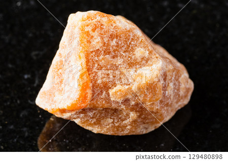 sample of raw heliolite sunstone mineral on black 129480898