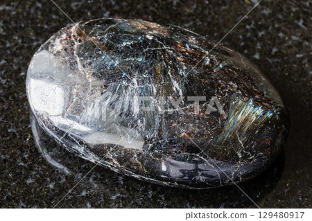 sample of polished nuummite mineral on black sample of polished nuummite mineral on black 129480917