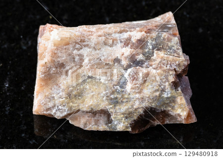 sample of raw nepheline rock on black granite sample of raw nepheline rock on black granite 129480918