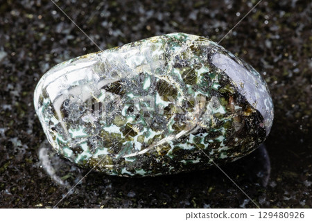 tumbled gabbro-norite mineral on black granite 129480926