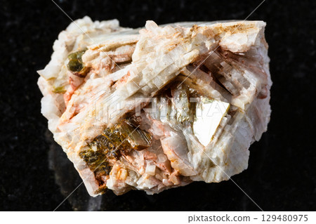 sample of raw albite rock with muscovite on black 129480975