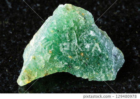 sample of raw green aventurine mineral on black 129480978