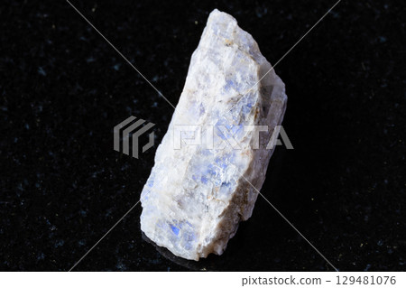 sample of raw belomorite mineral on black granite 129481076