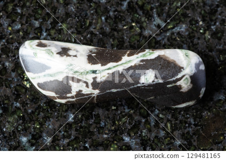 sample of tumbled hornfels mineral on black 129481165