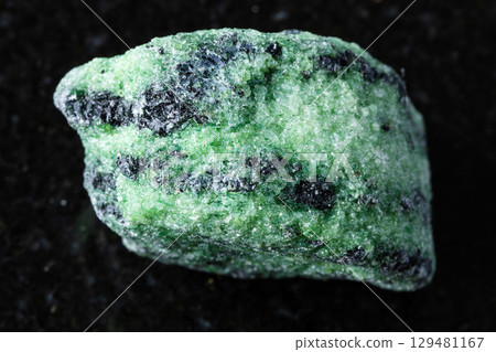 sample of raw zoisite rock on black granite 129481167