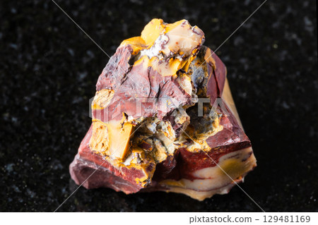 sample of raw colorful mookaite mineral on black 129481169