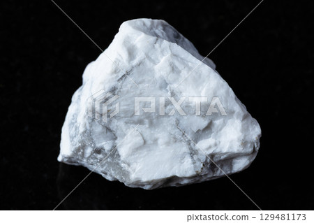 sample of raw howlite rock on black granite 129481173