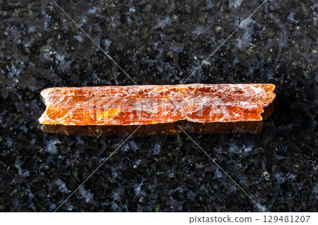 sample of raw orange kyanite crystal on black 129481207